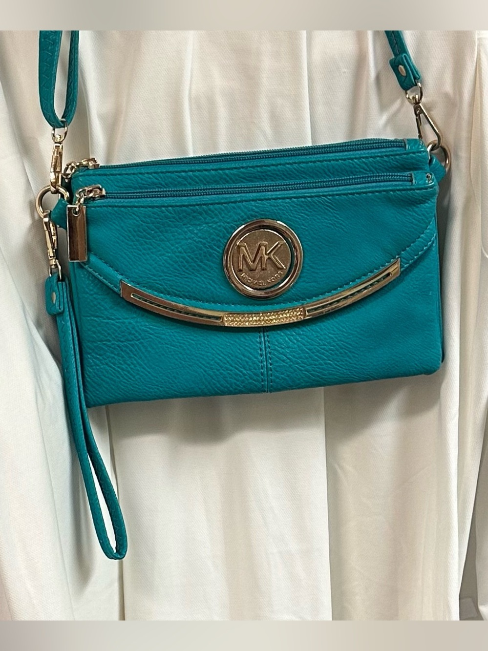 Michael Kors Fulton aqua pebbled leather crossbody bag with a gold metal logo